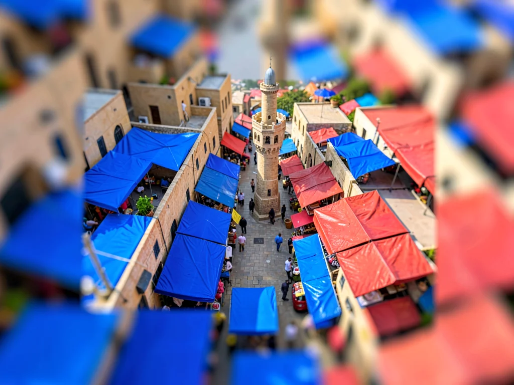 Above a souk tilt-shift photograph from a minaret, saturated cobalt awnings and 