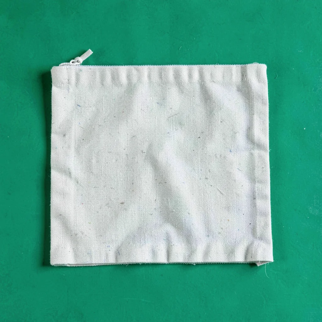 single foldable canvas makeup-kit pouch flattened top-down on a saturated emeral