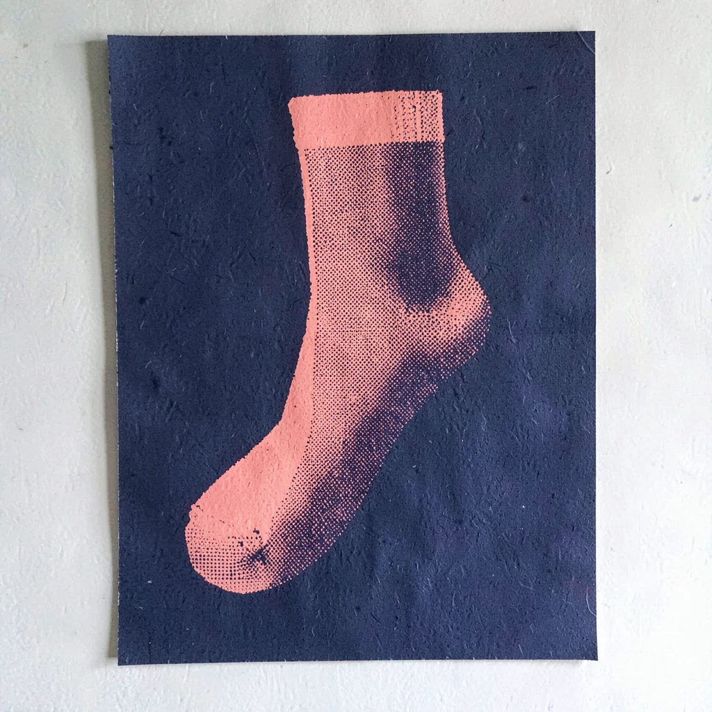 Bold screenprint poster of a halftone single-sock silhouette in coral over flat 
