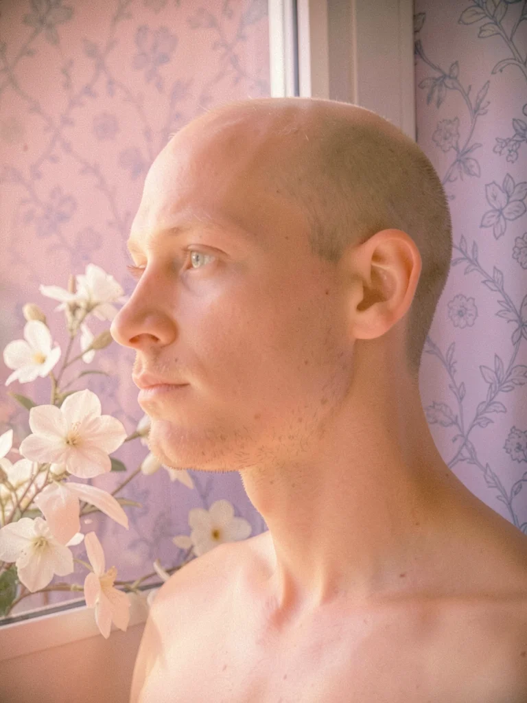 Man's profile turned to the side in soft window light with peach skin and a fain