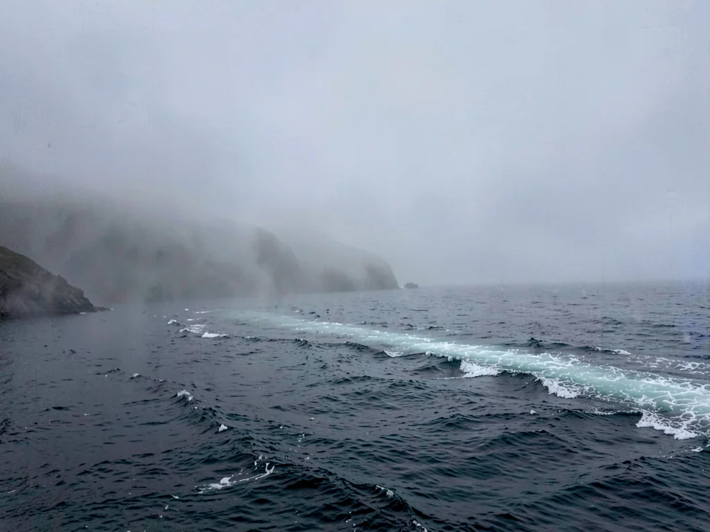 Ferry wake disappearing into mist distance