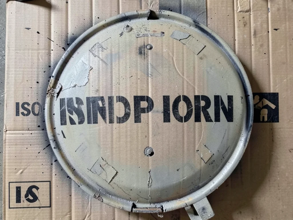 A cement mixer truck drum with the company name in large stenciled letters wrapp