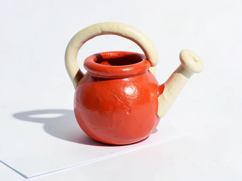 Tubby chunky clay watering pot in cherry red with stubby cream-toned handle and 