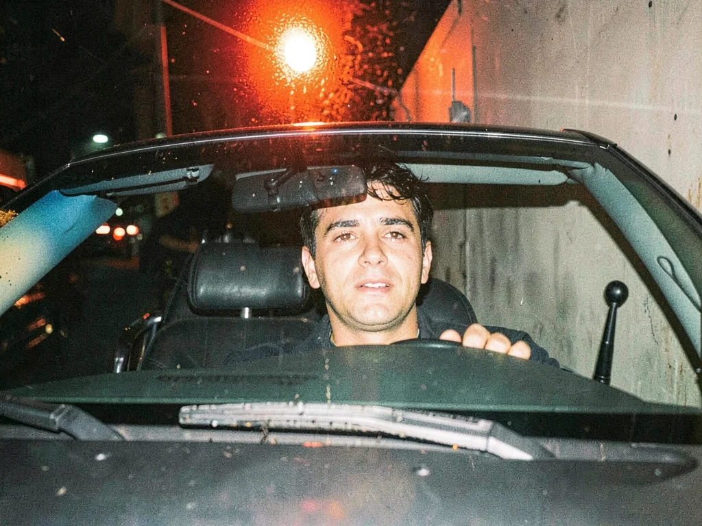 Taxi driver through windshield at a red light, dashboard glow and flash competin