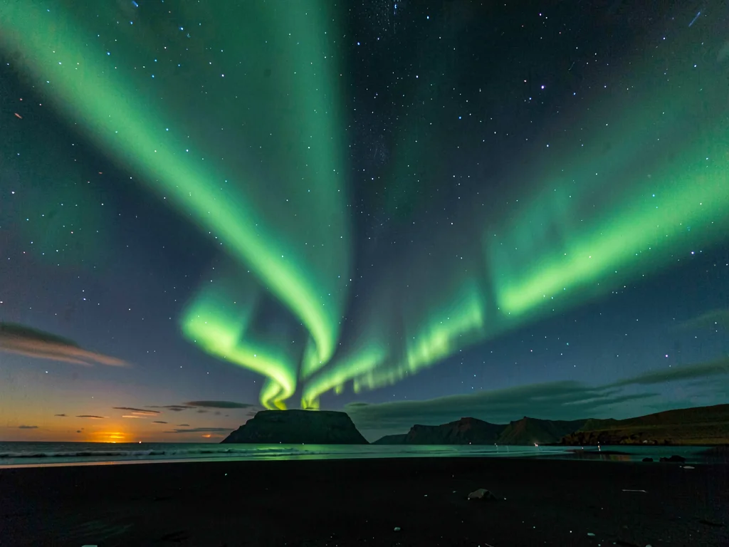 The northern lights over Iceland, green curtains dancing across entire sky, blac