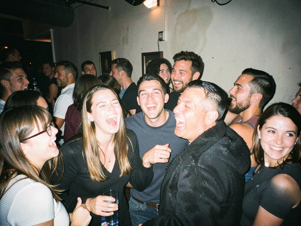 Party guests mid-laugh at crowded bar