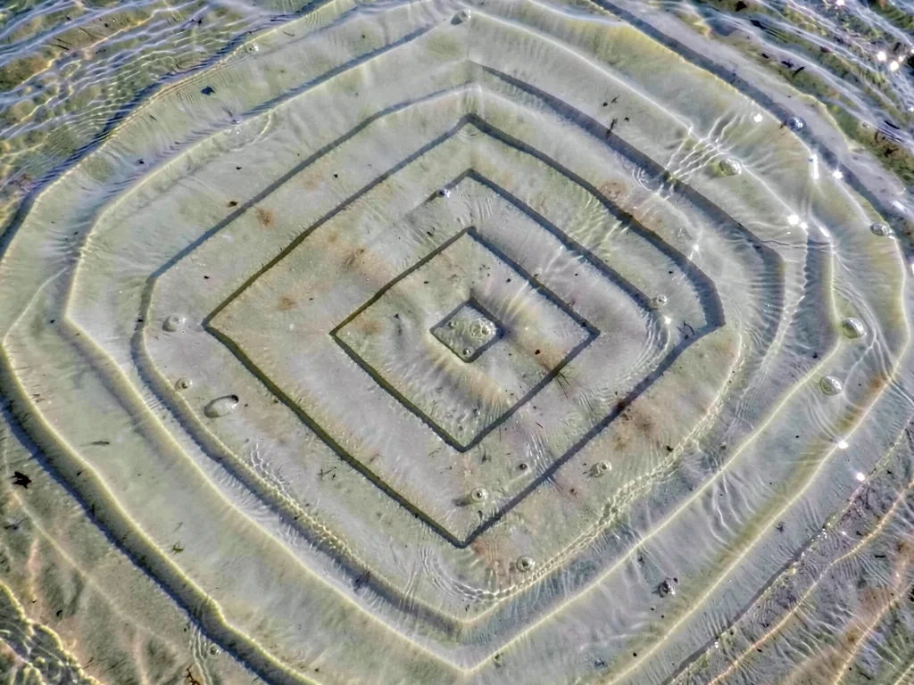 Standing wave pattern creating concentric squares in shallow water