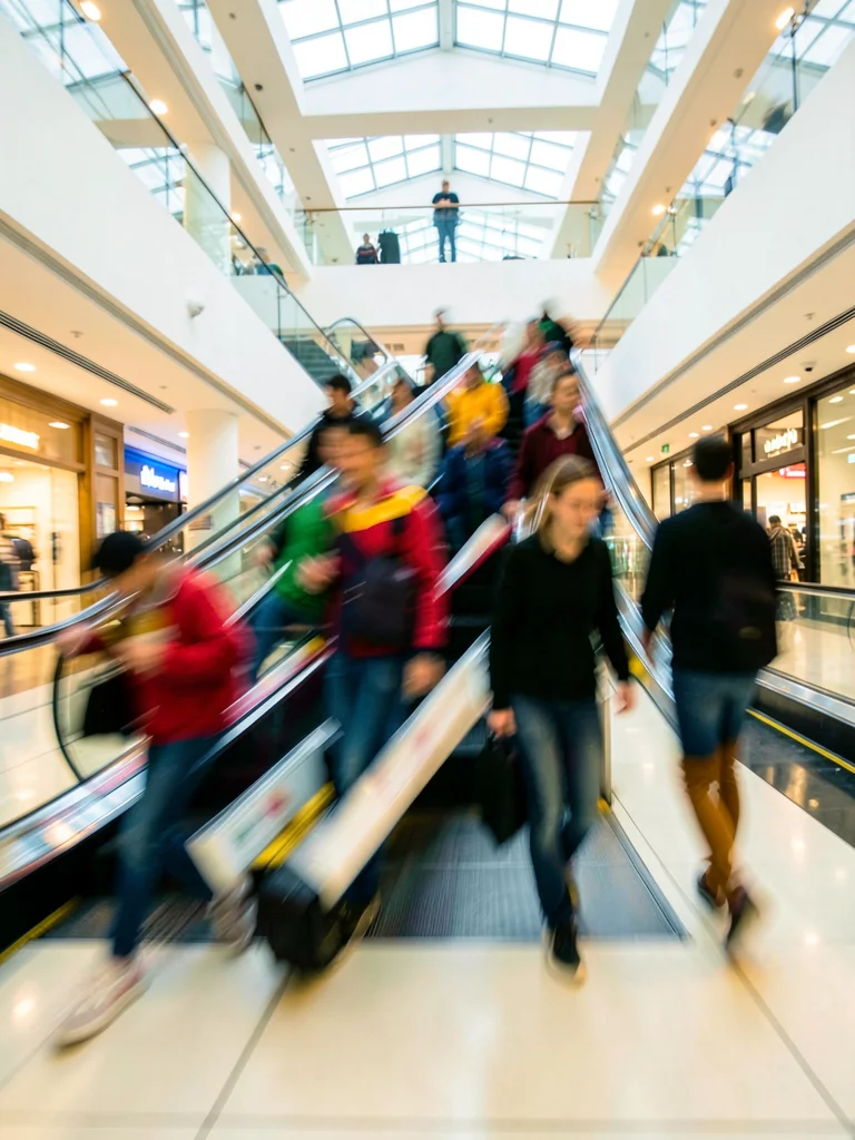 Escalator riders becoming ascending smears of color in mall atrium