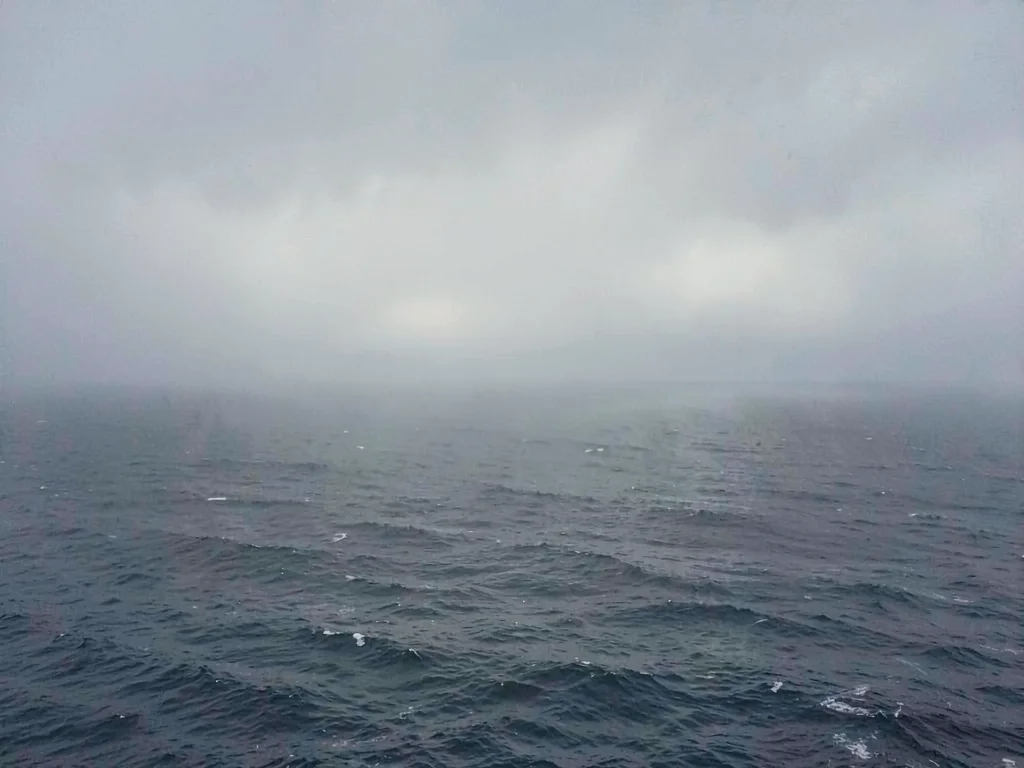 The sea meeting sky in dense fog, horizon line barely visible