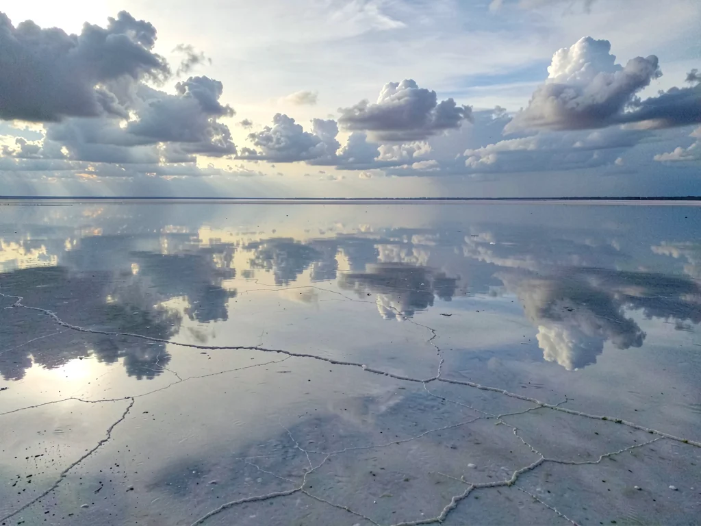Clouds extending continuously through mirror surface