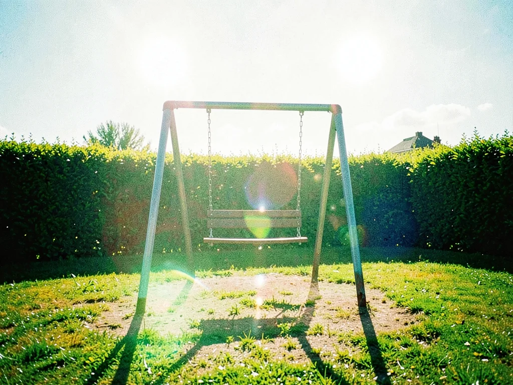 The empty seat of a swing set creaking in midday wind on a vacant playground bor