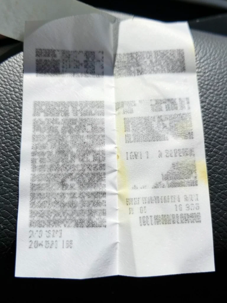 Thermal receipt exposed to sunlight on a dashboard, one half completely blanked,