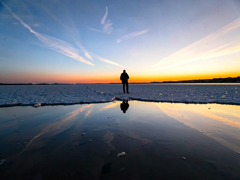 Silhouette floating in middle of reflected sky