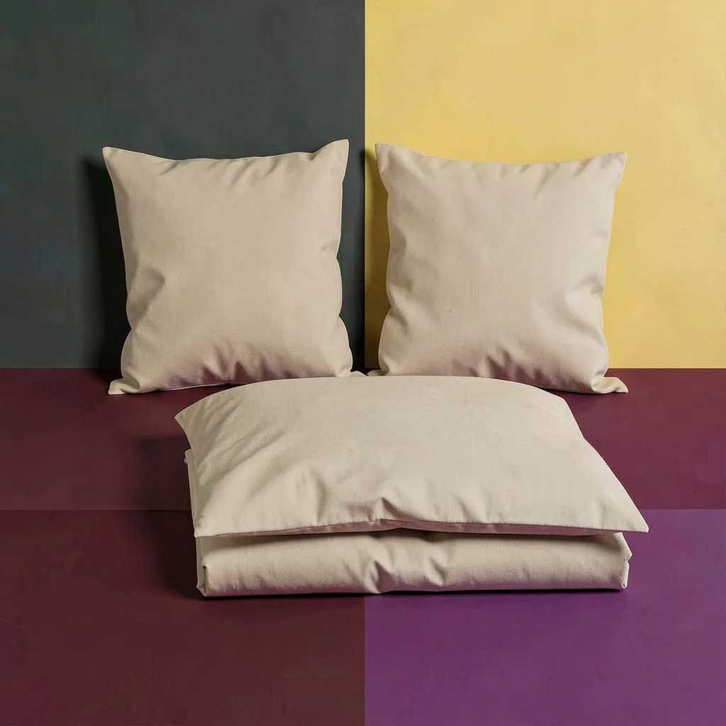Blockcolor range hero of two pillows and a folded duvet as flat planes, oat and 