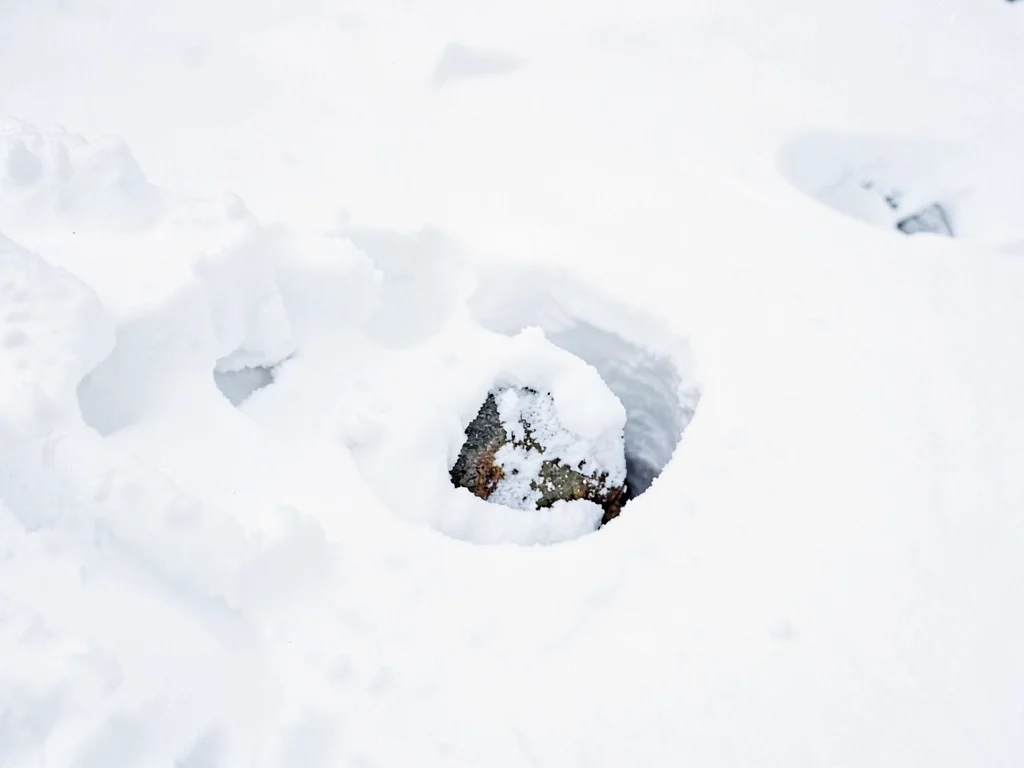 Single stone emerging from snow drift