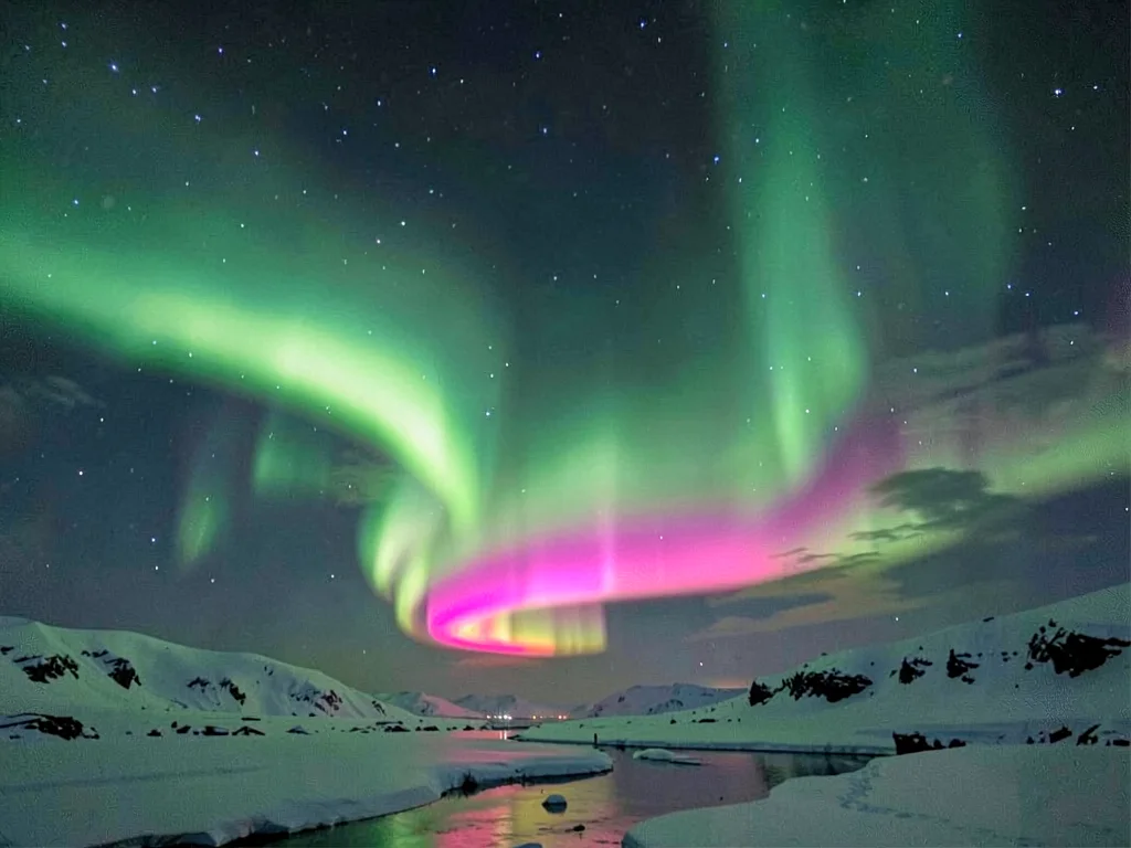 Green aurora with pink lower border showing altitude colors