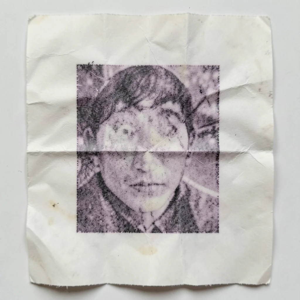 Crumpled receipt paper smoothed out, thermal print distorted by the wrinkle line