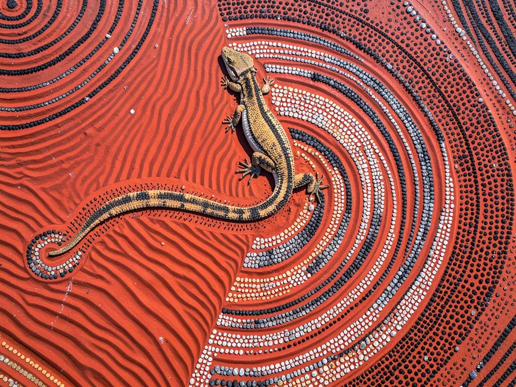 Sand ripples crossing red desert floor, aerial view, serpentine tracks of a liza