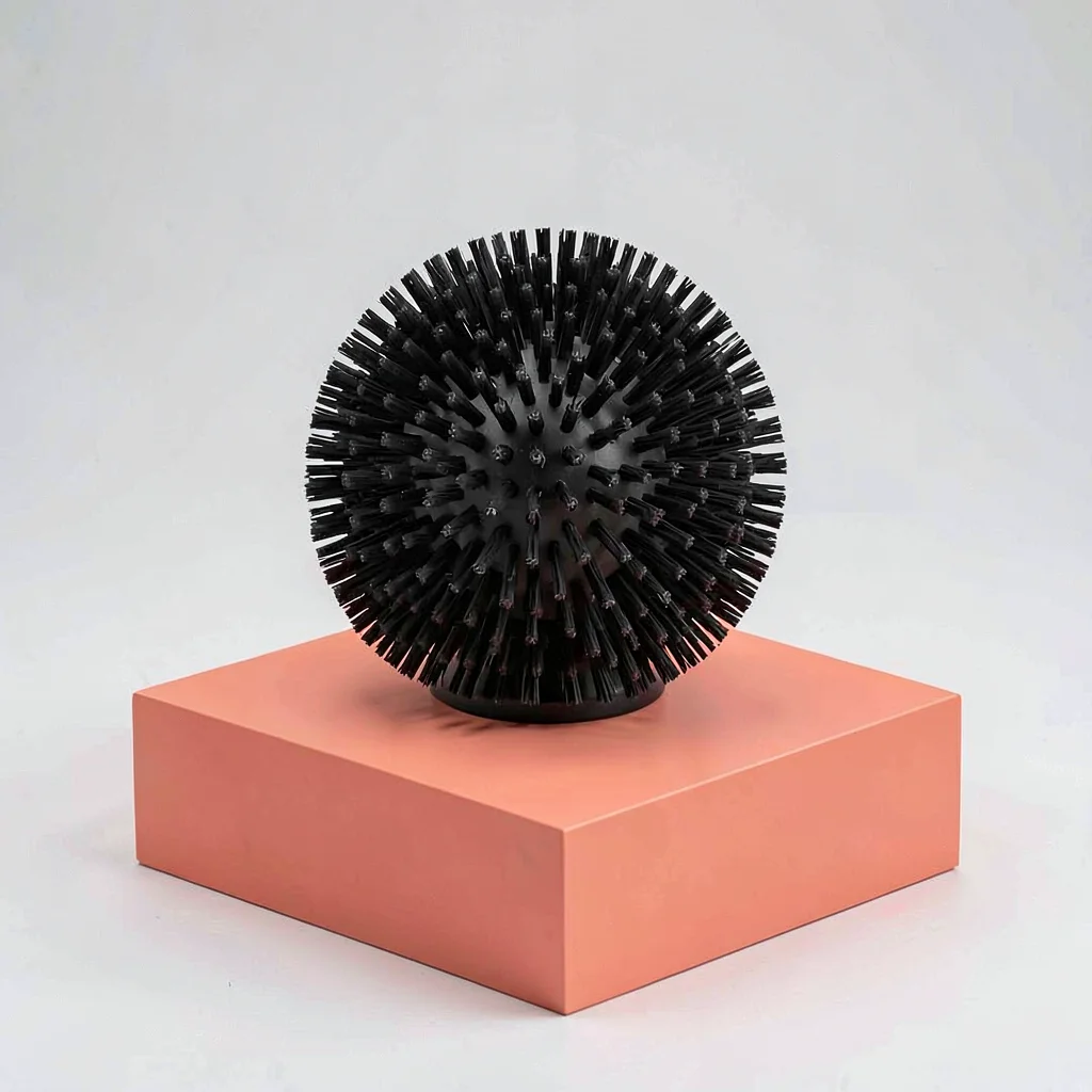Catalog square of a single rubber dog-brush mitt on a coral block, even diffuse 
