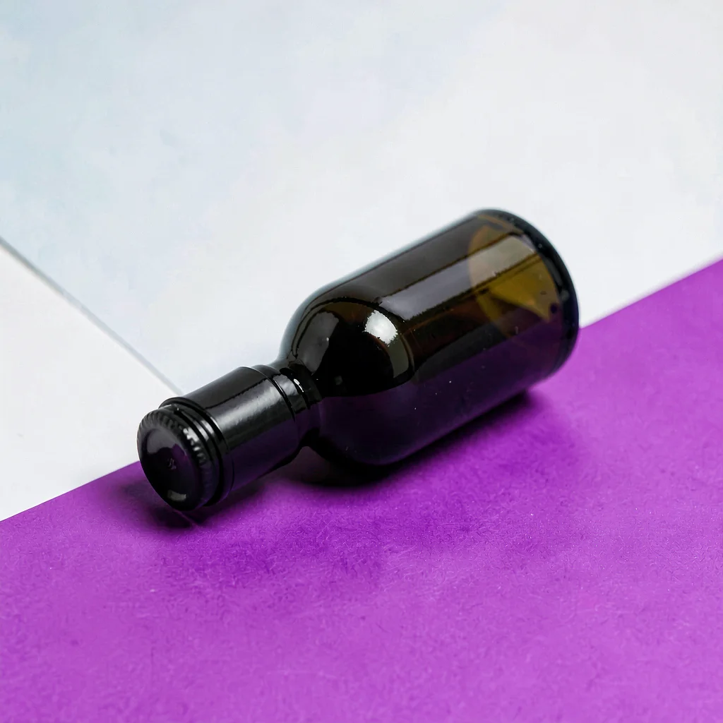 Single bottle lying on its side against a chalk-white seamless