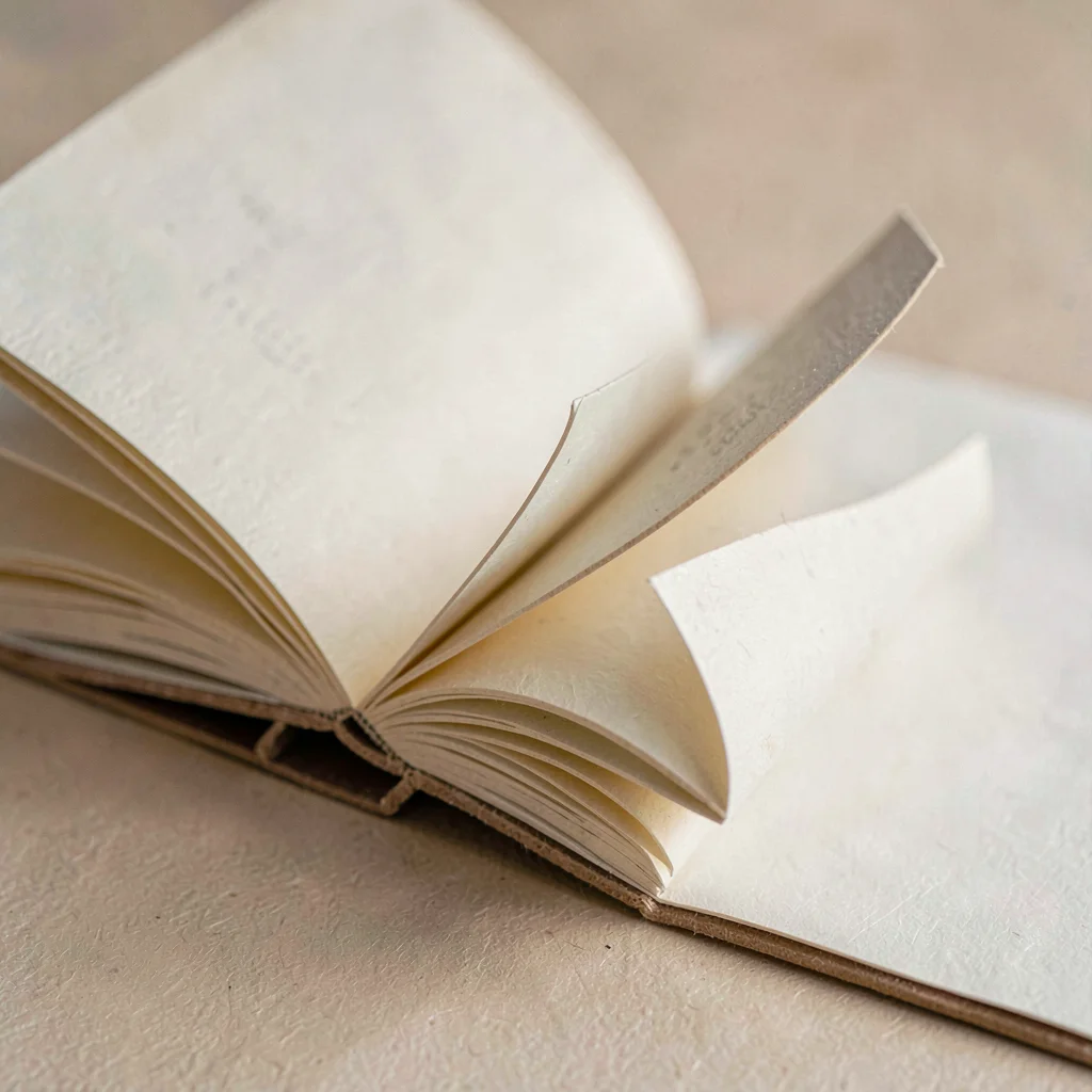 Open folded folio with pages curling slightly, fiber grain detail visible