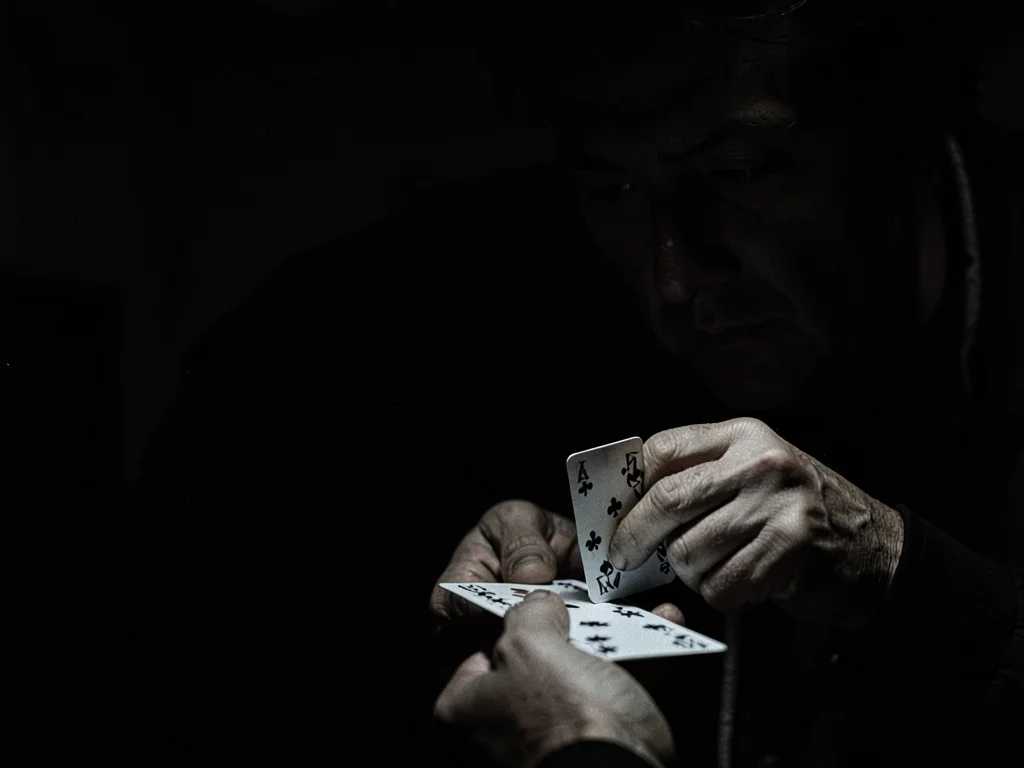 Hands dealing cards in darkness