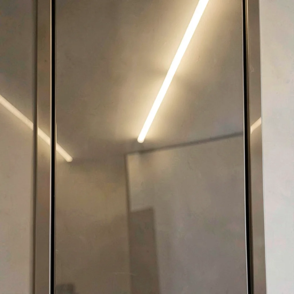 Surface study of a polished door panel reflecting a soft fluorescent ceiling lin