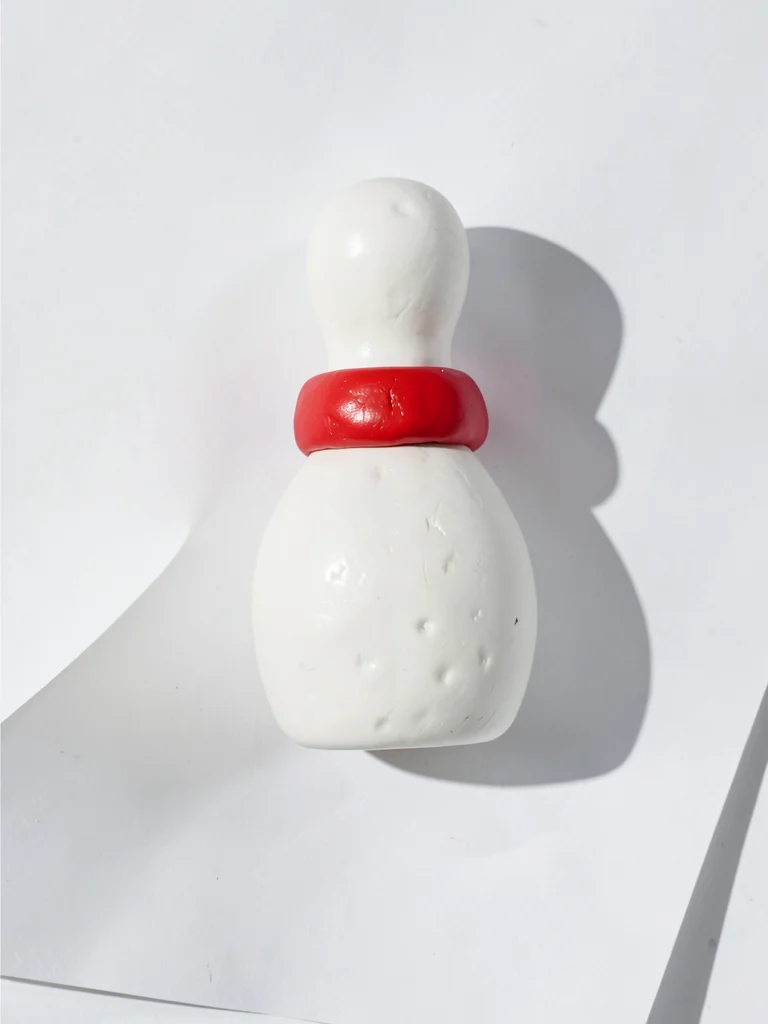 Round chunky clay bowling pin in primary white with stubby cherry-red squat band