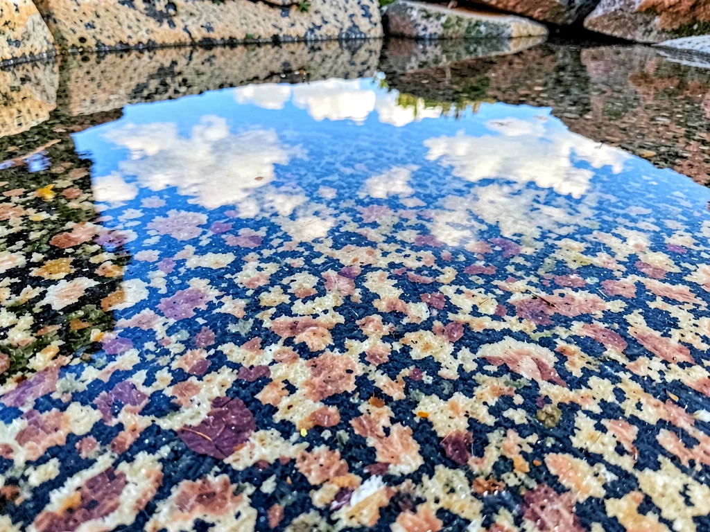 Surface pool reflecting sky on granite