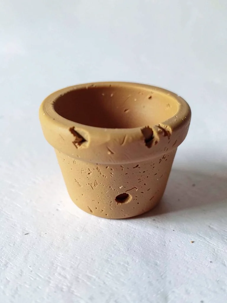 Earlier-fired ochre flowerpot with thumb dents around its rim and fingernail-pre