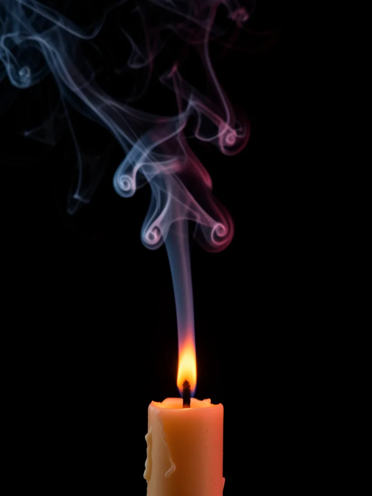 The moment of extinguishing a candle: the first instant of smoke, the wick still
