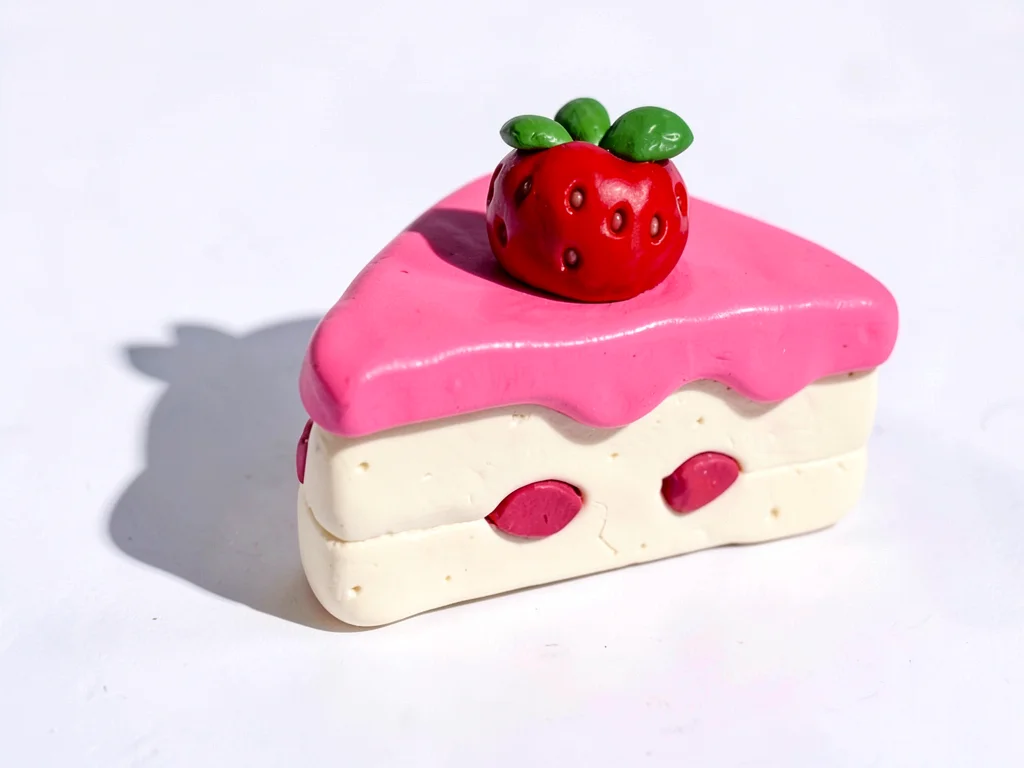 Squashy chunky clay slice of strawberry shortcake in cream-white with cherry-red
