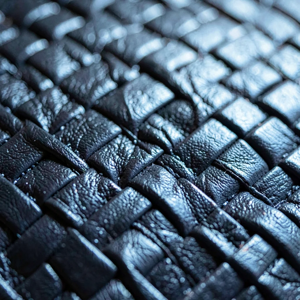 Macro of a leather bar-tape weave, slow oily sheen along the threads, hairline c