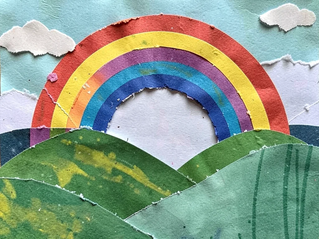 Paper collage rainbow over hills