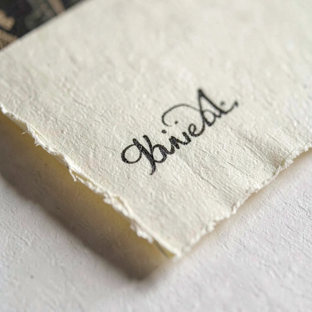 Macro of cream paper folded into a tight signature with deckle edges, pinpoint s