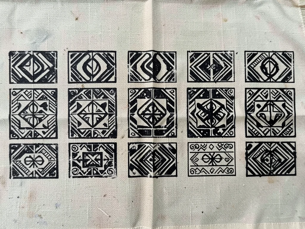 Multiple stamps in row — single symbol repeated across cloth, slight variation e