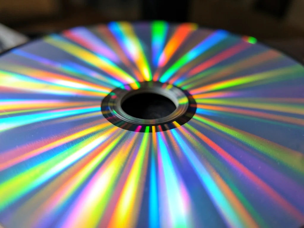 DVD data surface at steep angle, rainbow diffraction splitting overhead light in
