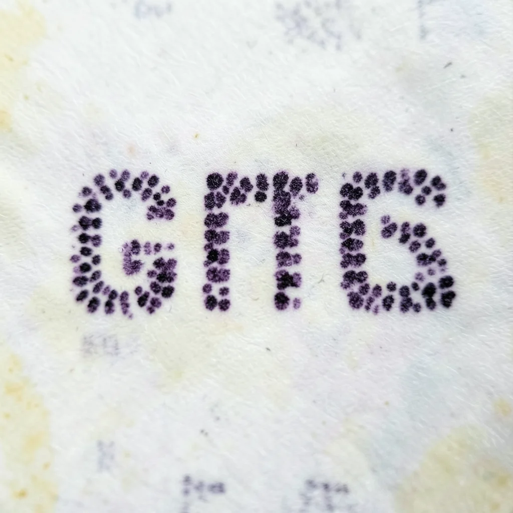 A close-up of thermal paper showing the characteristic purple-black dots that fo
